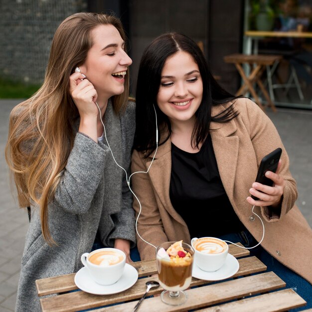 Woman showing a new song to her friend