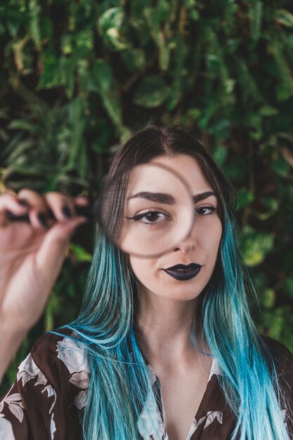 Woman showing one eye through a magnifying glass