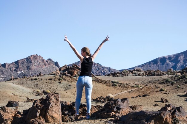 Woman showing peace sign with hands in air