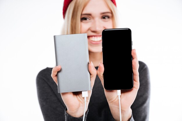 Woman showing power bank and smartphone