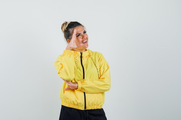 Woman showing salute gesture in sport suit and looking joyful. front view.