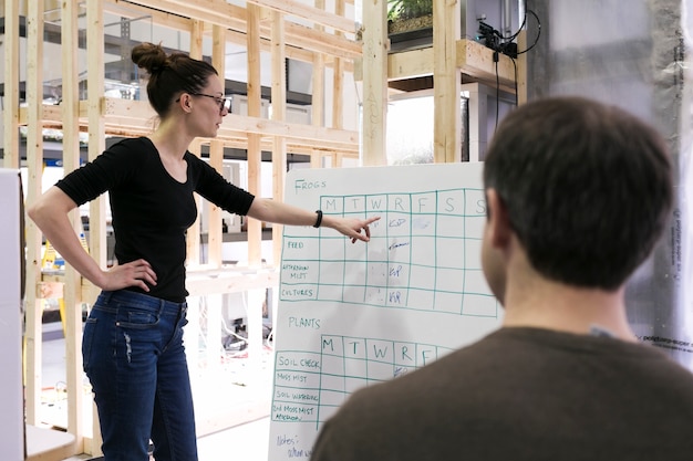 Free photo woman showing schedule to coworker