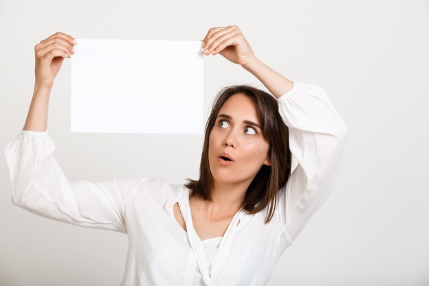 Woman showing sign on white paper, make announcement