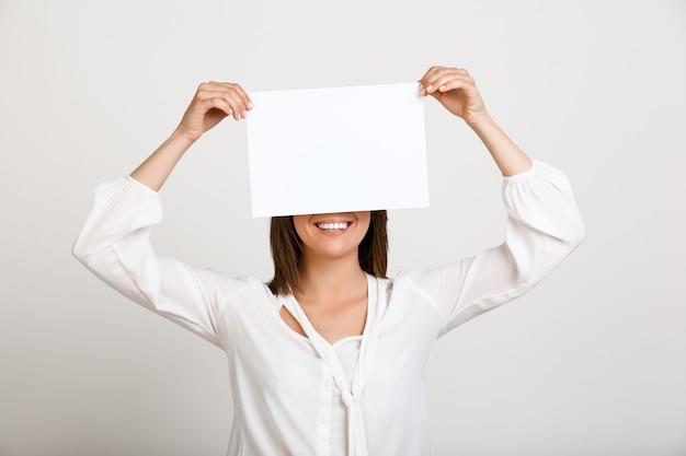 Free photo woman showing sign on white paper, make announcement