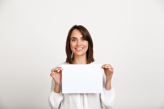 Woman showing sign on white paper