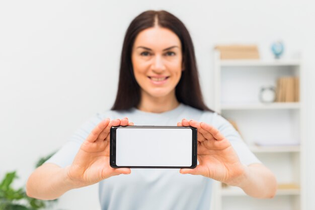 Woman showing smartphone with blank white screen