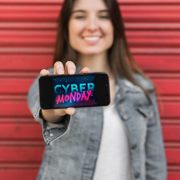 Woman showing smartphone with Cyber Monday picture 