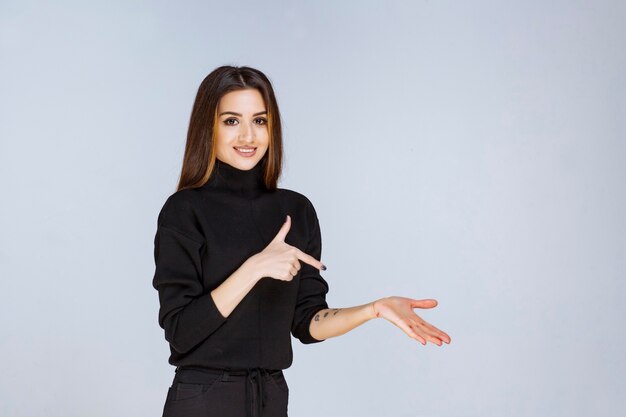 woman showing something on the right side. 