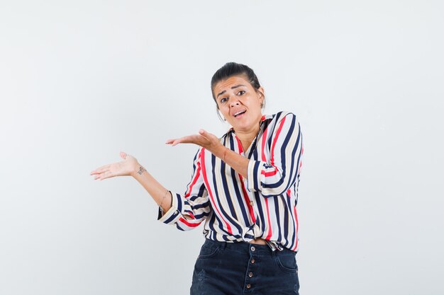 woman showing something or welcoming in shirt, skirt