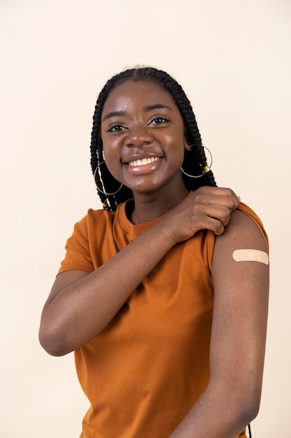 Woman showing sticker on arm after getting a vaccine