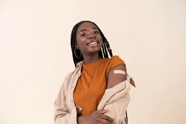 Woman showing sticker on arm after getting a vaccine