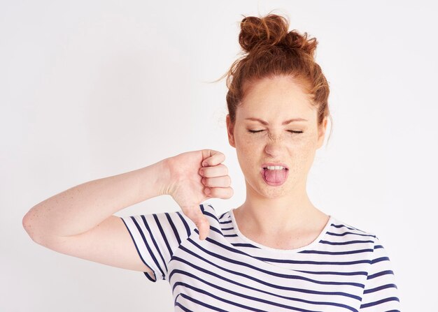 Woman showing thumb down and grimacing  shot