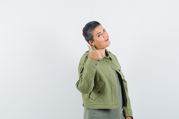 woman showing thumb up in jacket, t-shirt and looking confident