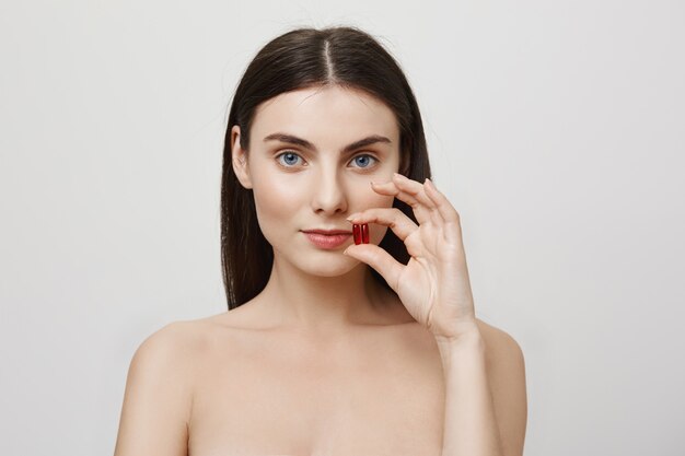 Woman showing vitamins, taking care of health