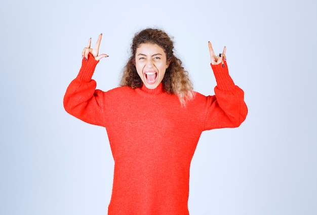 woman showing wolf head hand sign. 