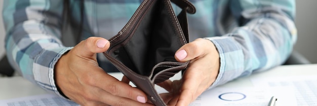 Woman shows empty wallet on table coins and documents business bankruptcy and not paying taxes