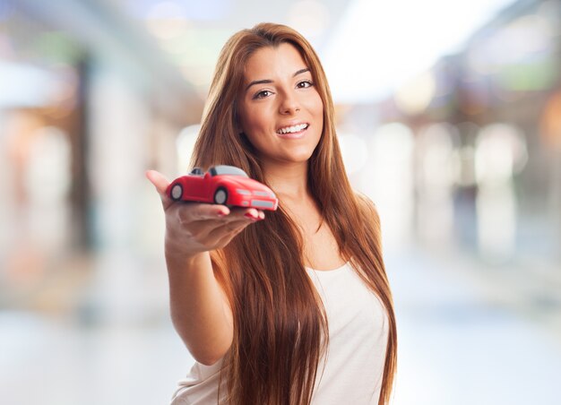 女性は、おもちゃの車を示しています。