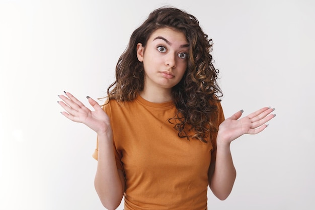 Free photo woman shrugging unaware raise hands clueless widen eyes surprise cannot answer question have no idea standing confused uncertain shaking head negative reply white background