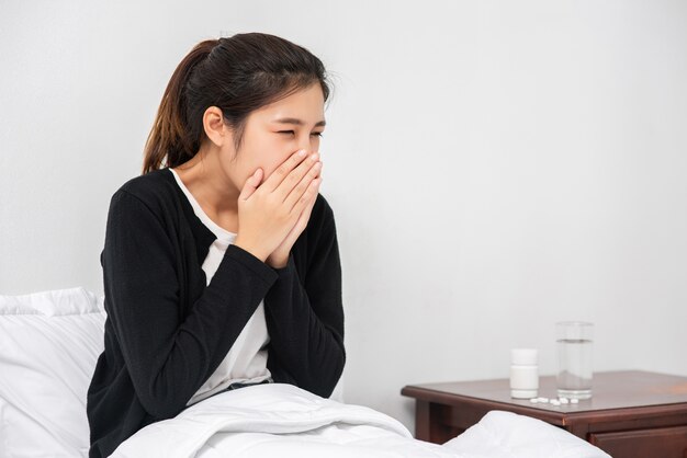 A woman sick with a toothache and a hand holding on the cheek