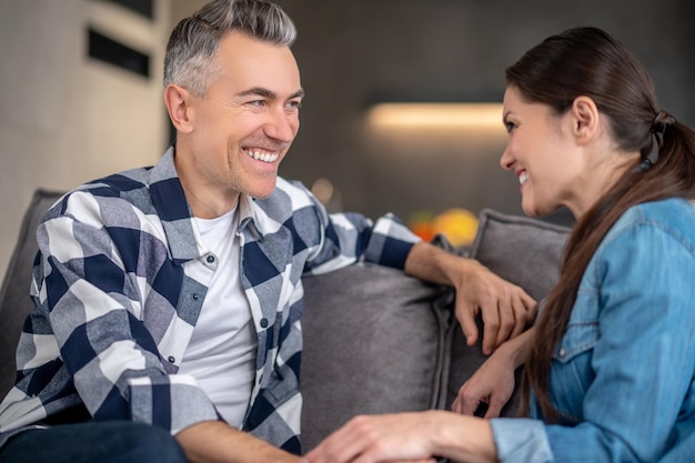 Free photo woman sideways to camera and man sitting on sofa