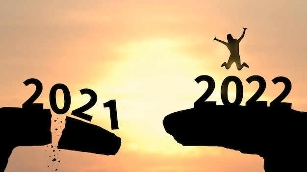 2022​年​の​数字​に​ジャンプする​女性​の​シルエット​明けまして​おめでとう​ございます​2022​年​お祝い​の​コンセプト​お​楽しみ​ください​幸せ