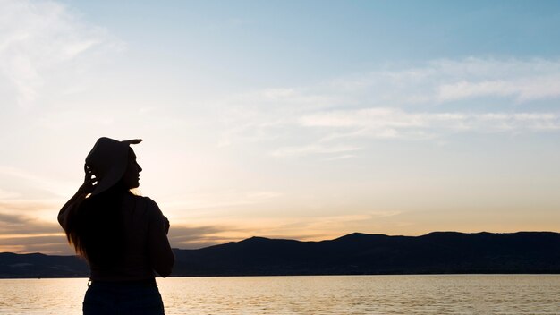 Woman silhouette at sunset with mountains