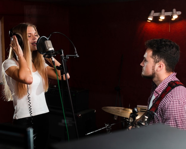 Woman singing in the microphone and guy playing guitar