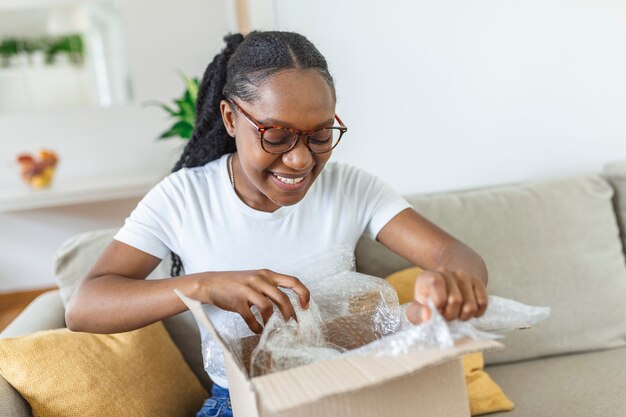 Woman sit on couch screaming with joy opens carton box feel happy, addressee girl received long-awaited package, fast easy and quick post mail parcel delivery, reliable postal courier service concept