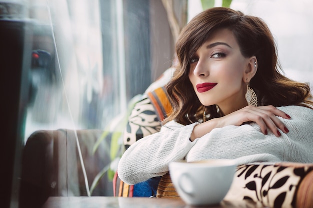 Free photo woman siting on a chair in a cafe