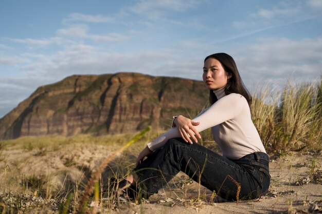 Woman sitting on beach full shot