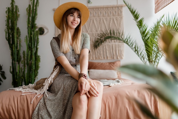 Woman sitting on bed in her boho apartment