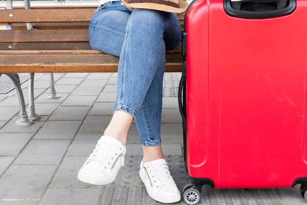 Woman sitting on a bench with luggage