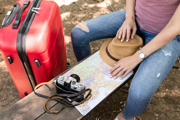 Woman sitting on a bench with travelling accessories