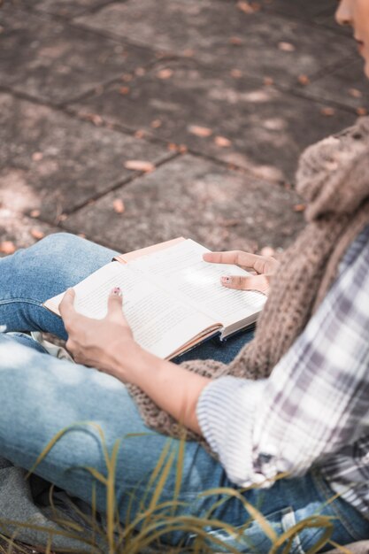 Woman sitting on board with book in sunny day 