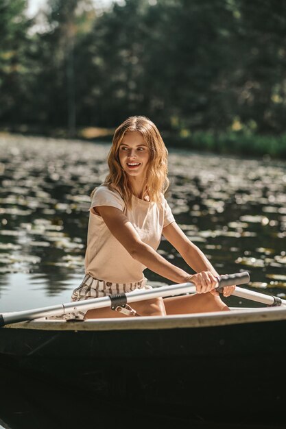 A woman sitting in a boat and oaring