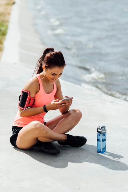 Free photo woman sitting next to a bottle