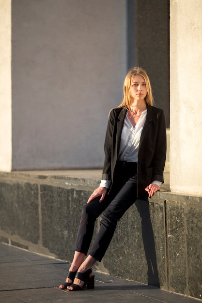 Free photo woman sitting on a building foundation