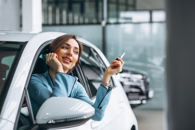 キーを押しながら車に座っている女性