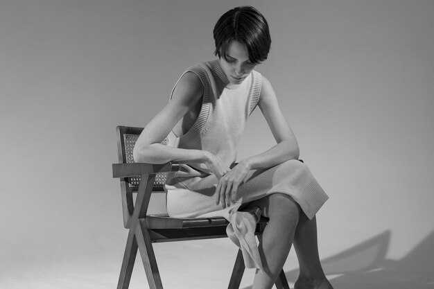Woman sitting on chair black and white side view