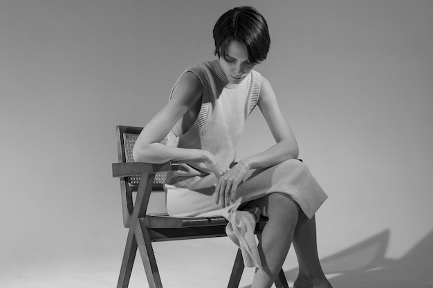 Woman sitting on chair black and white side view