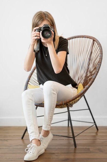 Free photo woman sitting on a chair long shot