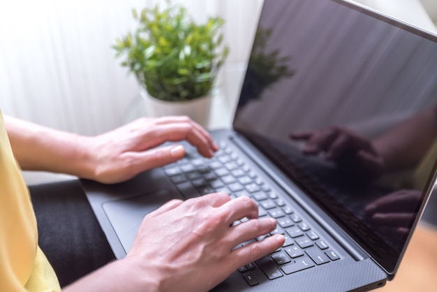 Woman sitting on a chair using a laptop on her lap