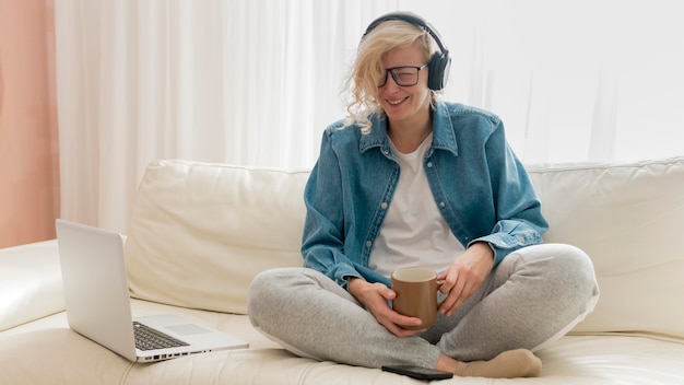 Woman sitting on couch and drinking coffee