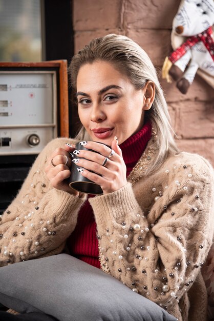 A woman sitting and drinking coffee