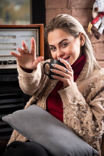 Женщина сидит и пьет кофе