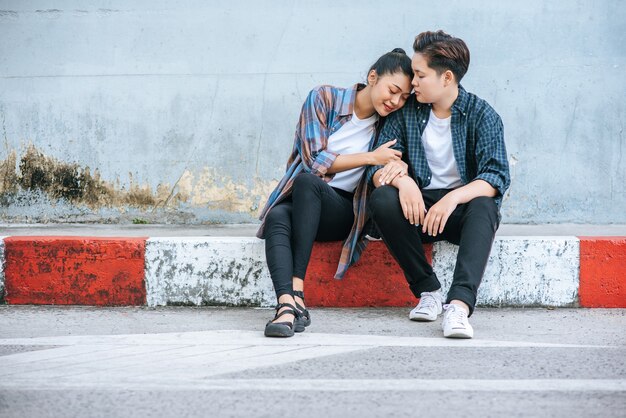 A woman sitting on each other's shoulders by the road.