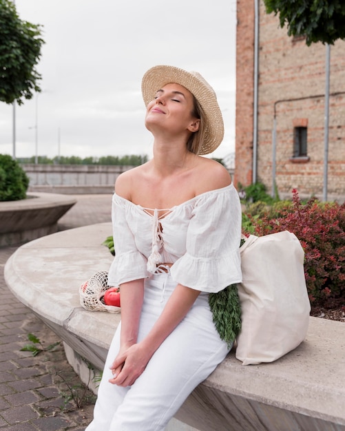 Foto gratuita donna seduta e godersi il sole