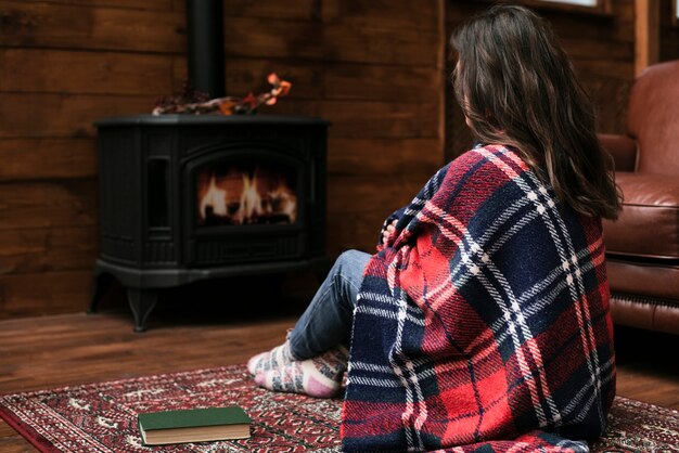 Woman sitting next to fireplace