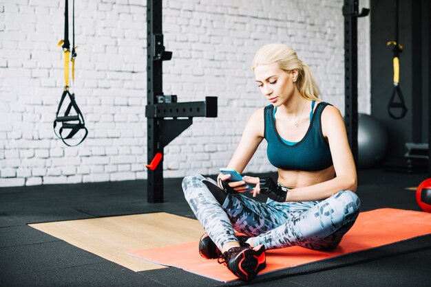 Woman sitting on floor and using smartphone