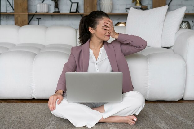 Woman sitting on the floor with a laptop on her lap